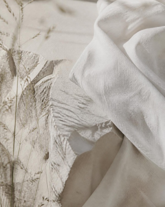 White linen draped over chalky limestone with wild grasses